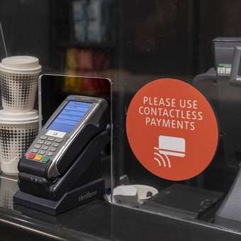 Card machine and a sign saying please use contactless payments.