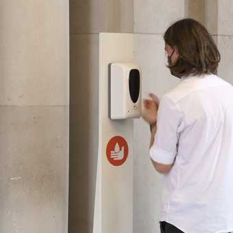 Person using hand sanitiser in the gallery.